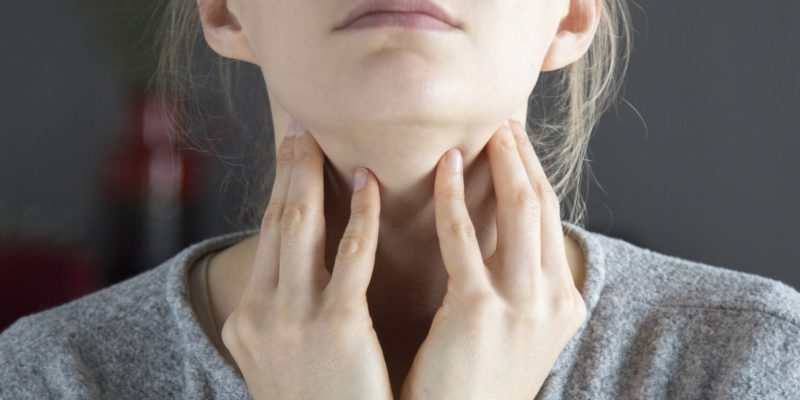 Sick woman with closed eyes having sore throat, touching neck Sick young fair-haired Caucasian woman with closed eyes having sore throat, touching her neck. Illness, pain concept